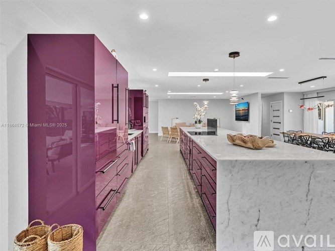 A kitchen with purple cabinets and a marble countertop.