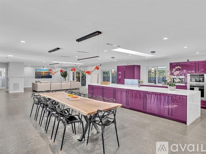 A modern kitchen with a dining table set up with chairs.