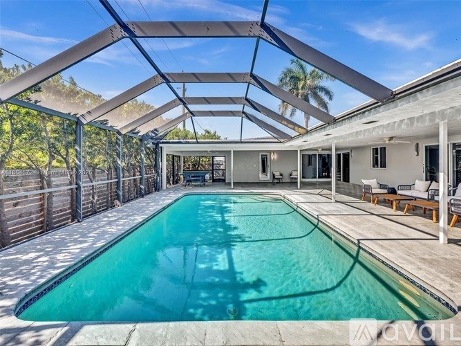 A swimming pool in a sunroom with a glass ceiling.