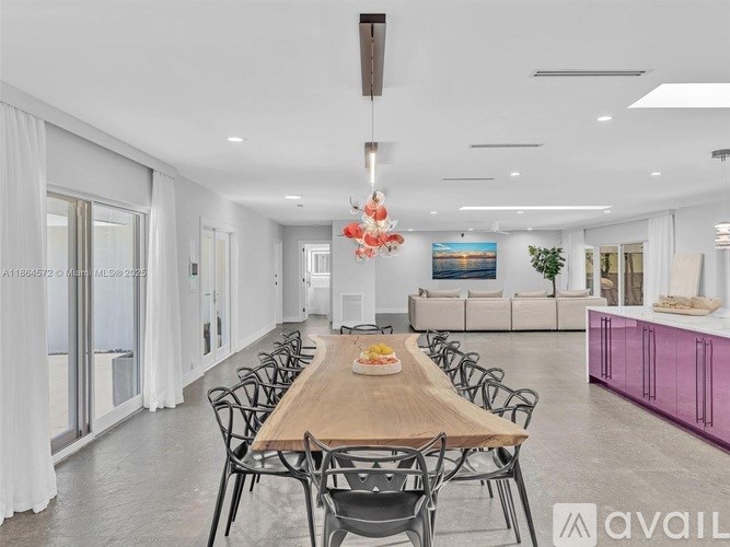 A dining room with a long table and chairs.