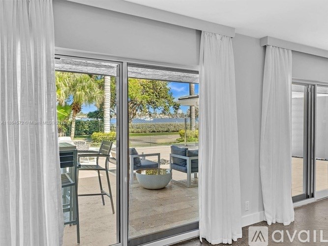 A patio with a table and chairs is visible through a sliding glass door.