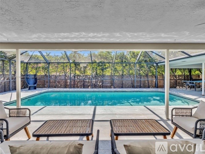 A pool area with a table and chairs.