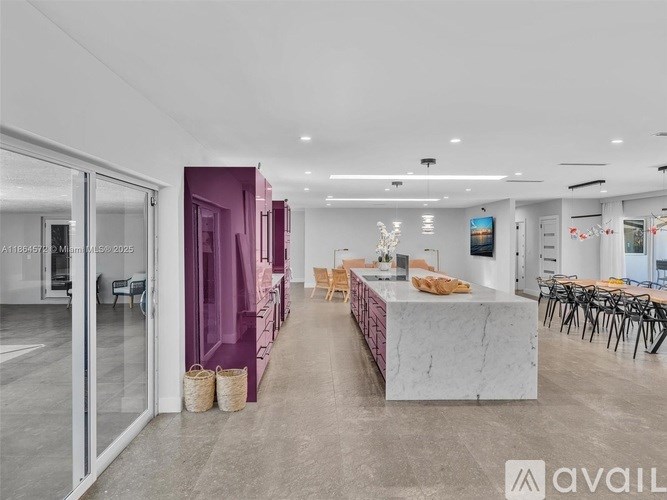 A spacious room with a marble counter and purple accents.