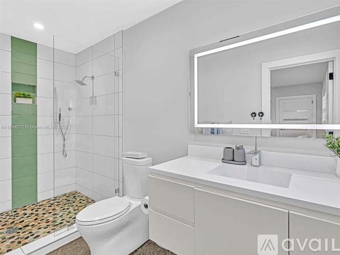 A white toilet sits next to a white sink in a modern bathroom.