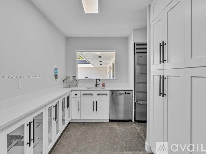 A kitchen with white cabinets and stainless steel appliances.