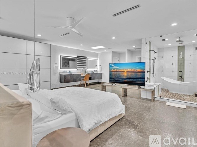 A modern bedroom with a large bed and a television displaying a sunset scene.