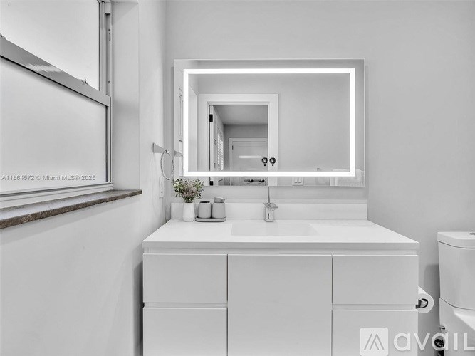 A white bathroom vanity with a mirror above it.