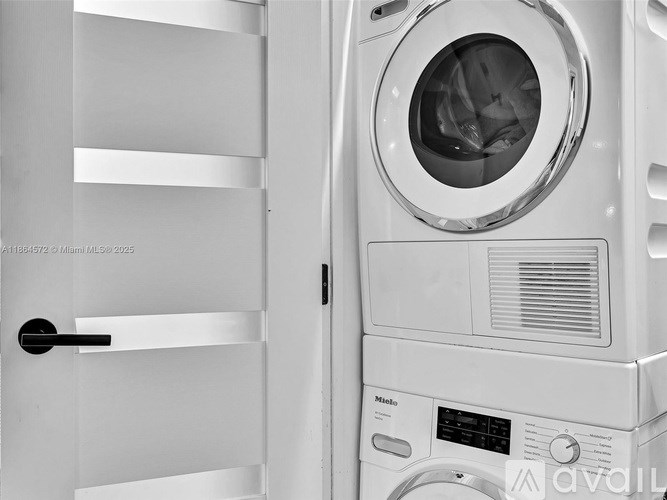 A washing machine is placed next to a door.