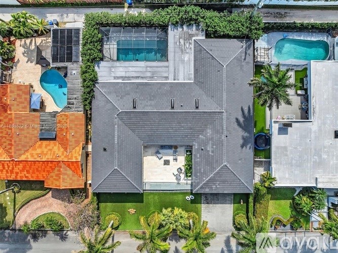 A modern house with a pool and a green lawn.