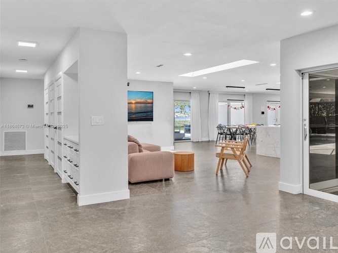 A spacious living room with a couch, chairs, and a painting on the wall.