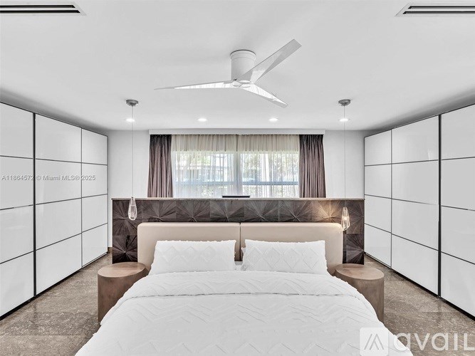 A bedroom with a large bed and a ceiling fan.
