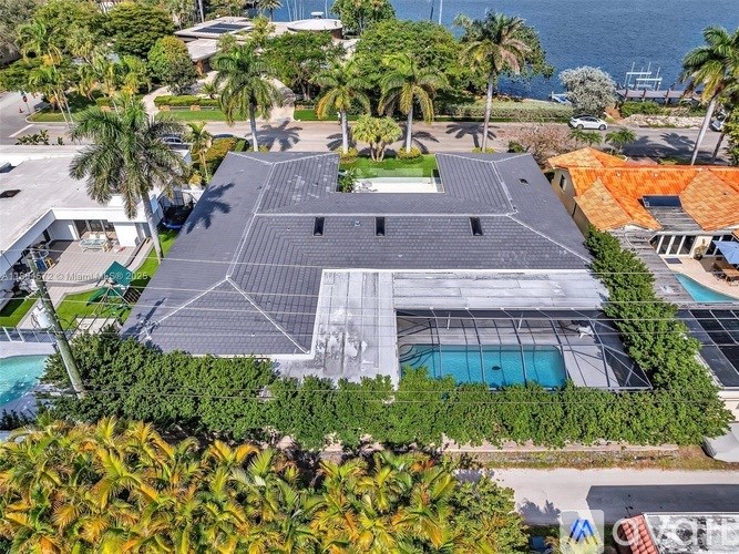 A large building with a pool in front of it surrounded by trees.