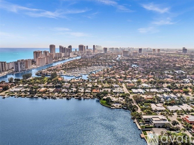 A cityscape with a body of water in the foreground and buildings in the background.
