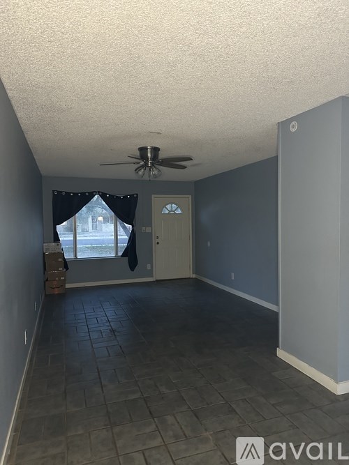 A room with a ceiling fan and a door leading to a balcony.
