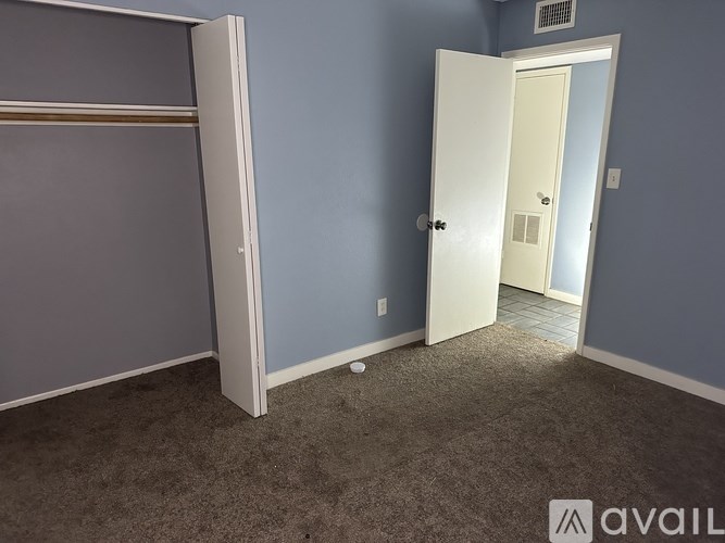 A room with a carpeted floor and a white door.