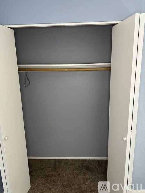 A white closet with a grey wall in the background.