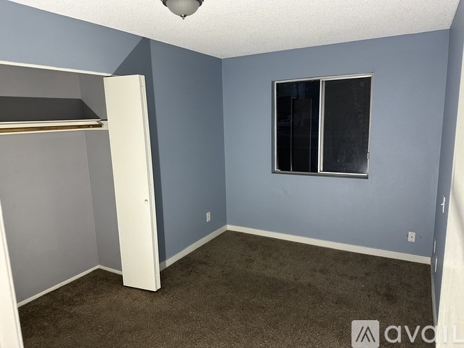 A room with a carpeted floor and a white door.