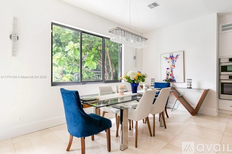 A modern dining room with a glass table and chairs.