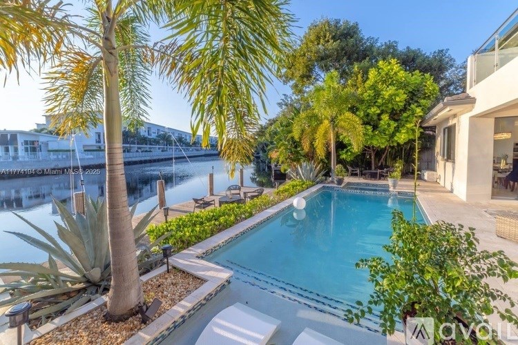 A pool surrounded by palm trees and plants.