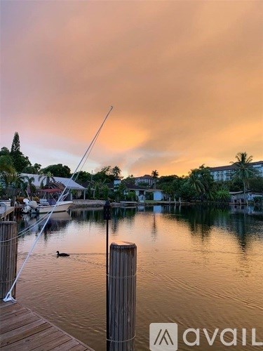 A dock with a fishing rod on it and a duck swimming in the water.