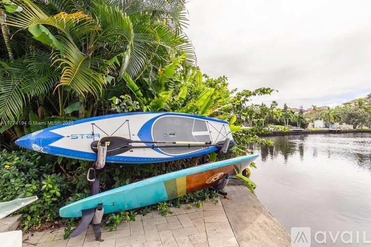 A blue and white surfboard with the word "STAR" written on it is leaning against a green surfboard.