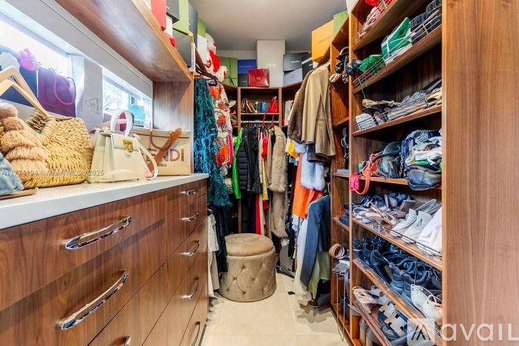 A walk-in closet with a variety of clothes and shoes.