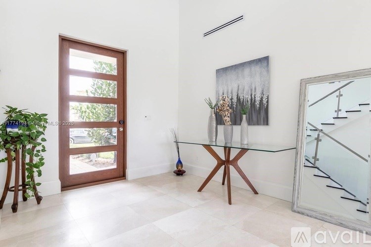 A room with a glass table and a painting on the wall.