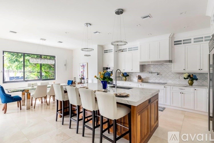 A kitchen with a large island and chairs.