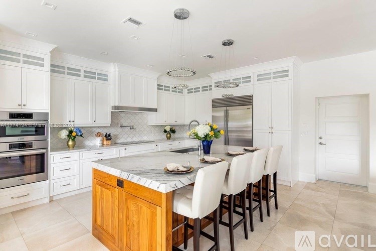 A kitchen with a center island and white cabinets.