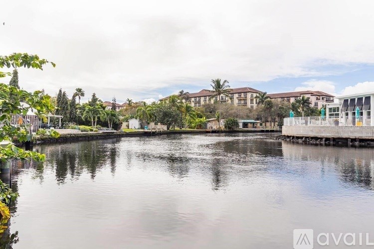A calm body of water reflects the sky and the buildings in the background.
