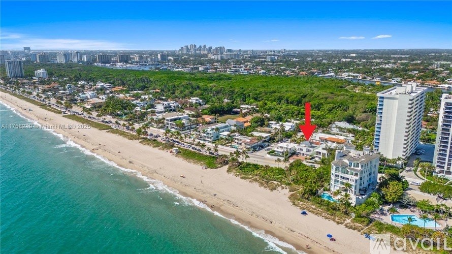 An aerial view of a beachfront with a red flag in the foreground.