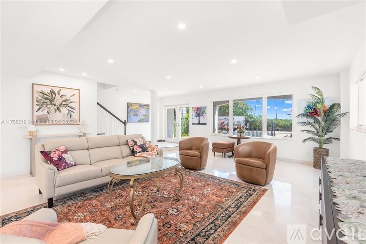 A living room with a sofa, armchairs, and a coffee table.