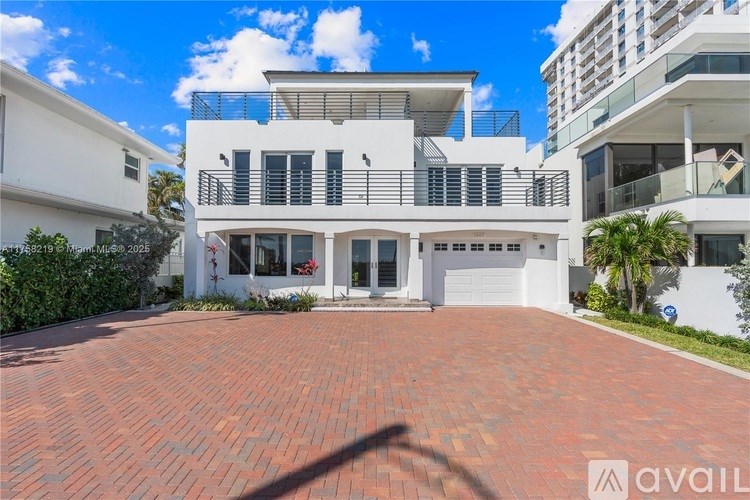 A modern two-story house with a red brick driveway.