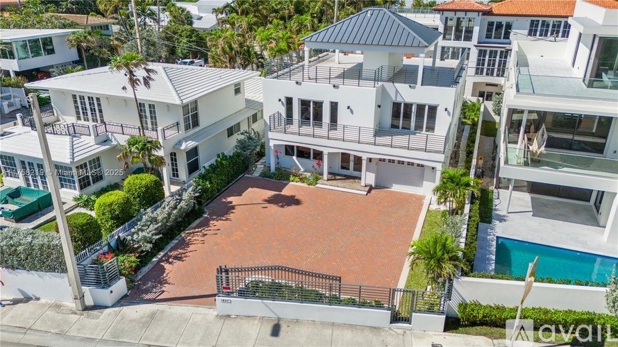 A large, multi-level house with a pool in the backyard.