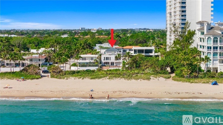 A beachfront property with a red arrow pointing to a building.