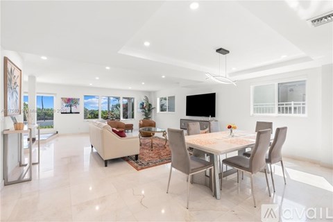 A spacious living room with a dining table set up with chairs.