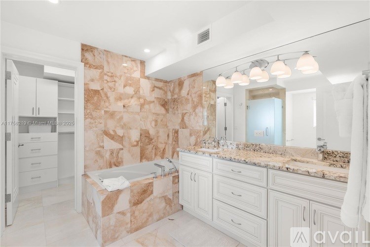 A bathroom with a stone wall and a bathtub.