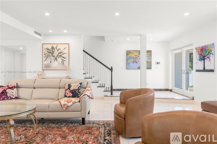 A living room with a beige couch, a glass table, and a rug.