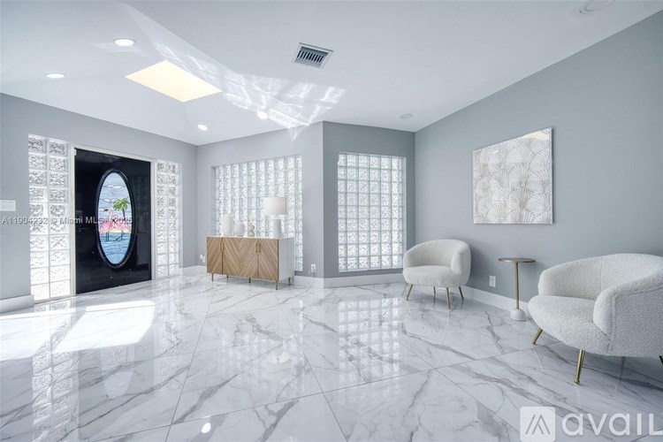 A spacious room with marble flooring and a large painting on the wall.