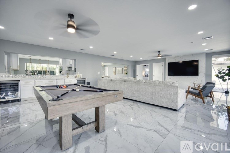 A modern living room with a pool table and a television.