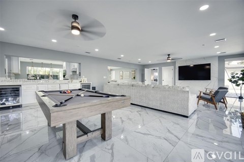A modern living room with a pool table and a television.