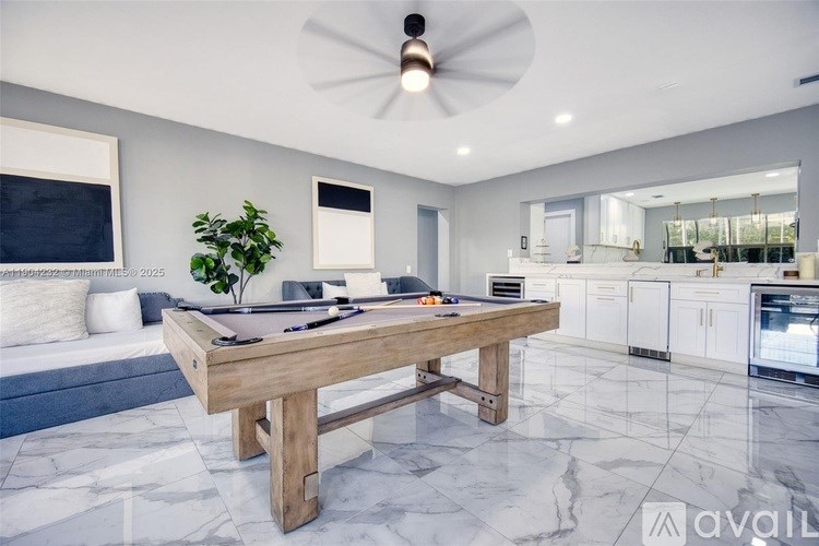 A modern kitchen with a wooden table and a ceiling fan.