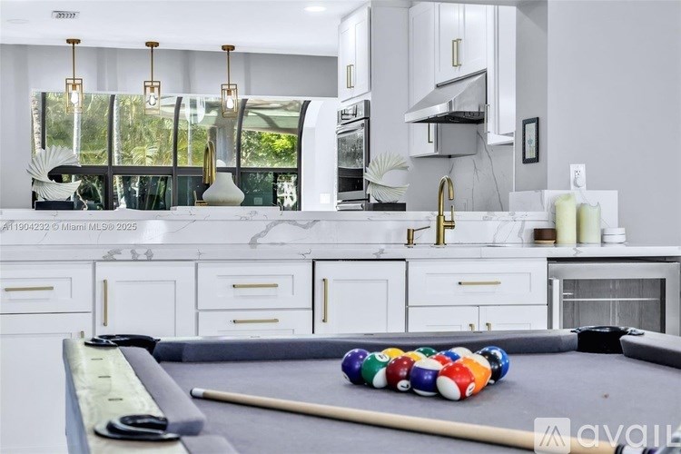 A pool table with a billiard ball set up in a modern kitchen.