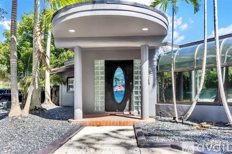A modern house with a curved roof and a glass wall.