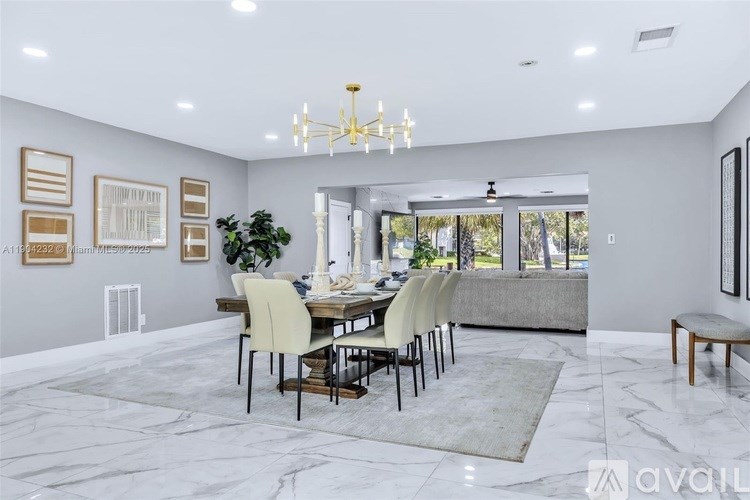 A dining room with a table set for six and a chandelier hanging from the ceiling.