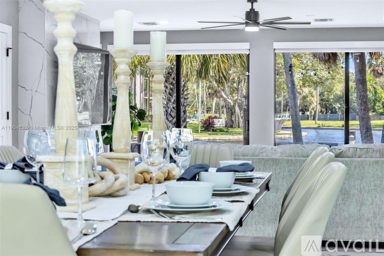A dining table set for a meal with a view of a garden outside.