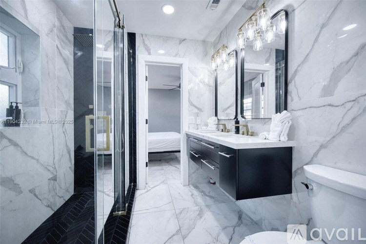 A bathroom with marble walls and a tub.