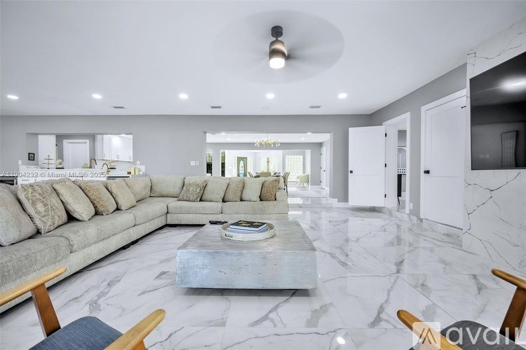 A modern living room with a grey sofa and a marble floor.