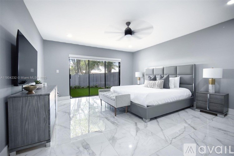 A modern bedroom with a large bed, a ceiling fan, and a marble floor.