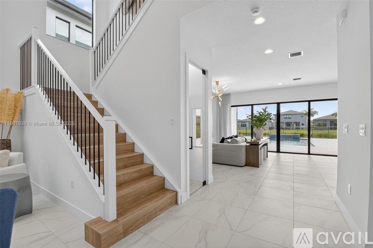 A spacious living room with a staircase leading to the upper level.
